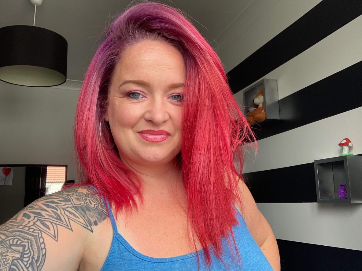 Woman with pink hair in living room