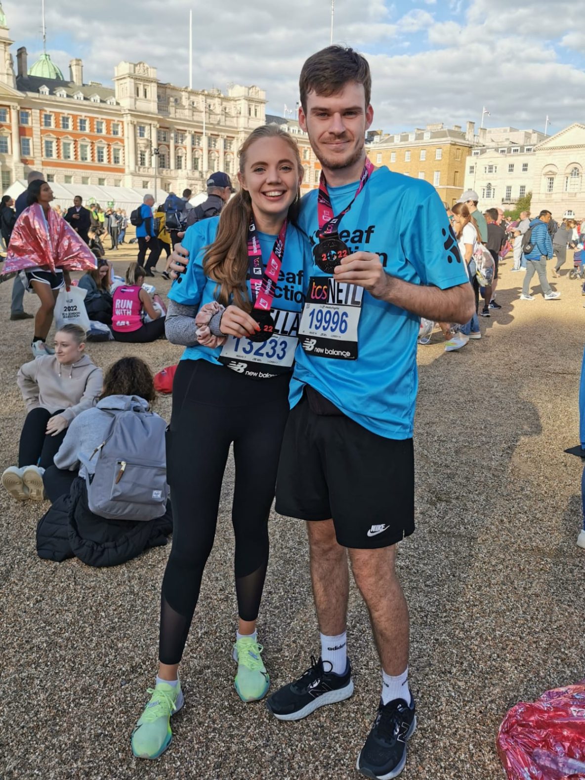 two people showing their London Marathon finisher medals