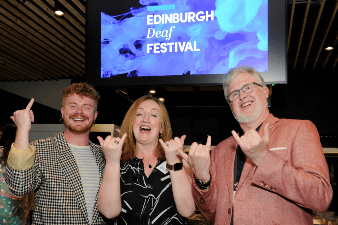 Three people signing 'festival'