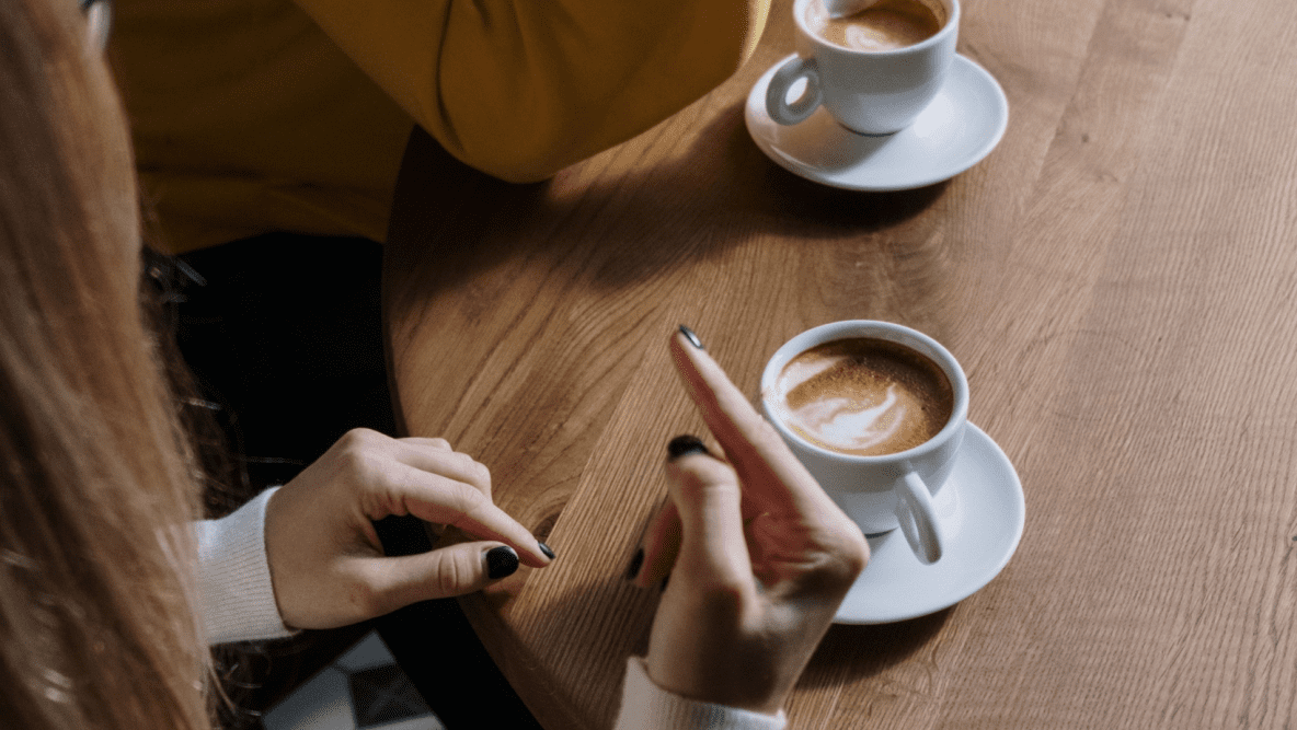 woman signing over a cup of coffee
